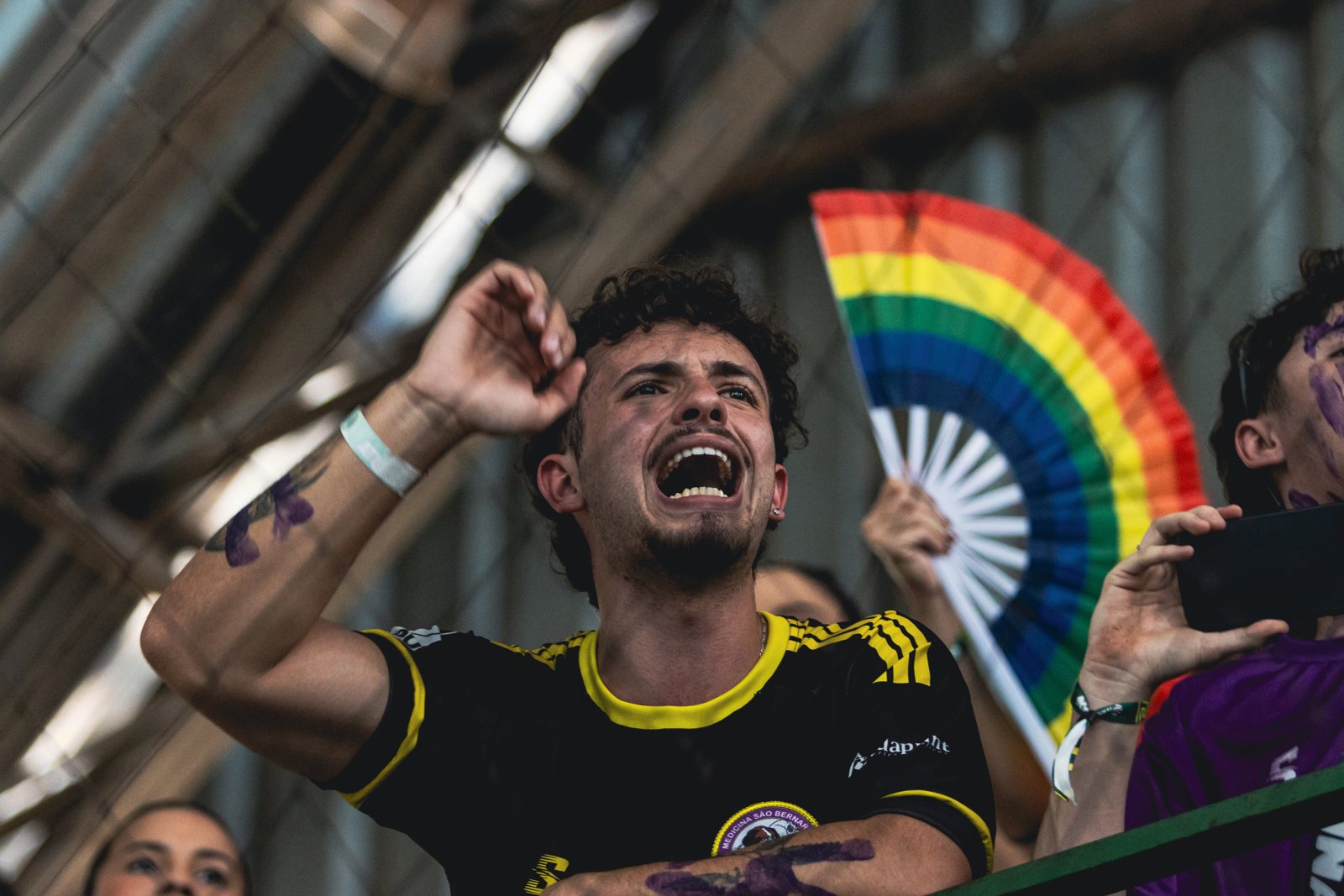 Torcida de atlética universitária vibrando na arquibancada